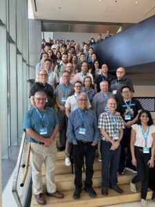 More than 60 attendees at the 2025 SEES-ISRD meeting gather on a stairway with their smiles showing for a group photo.